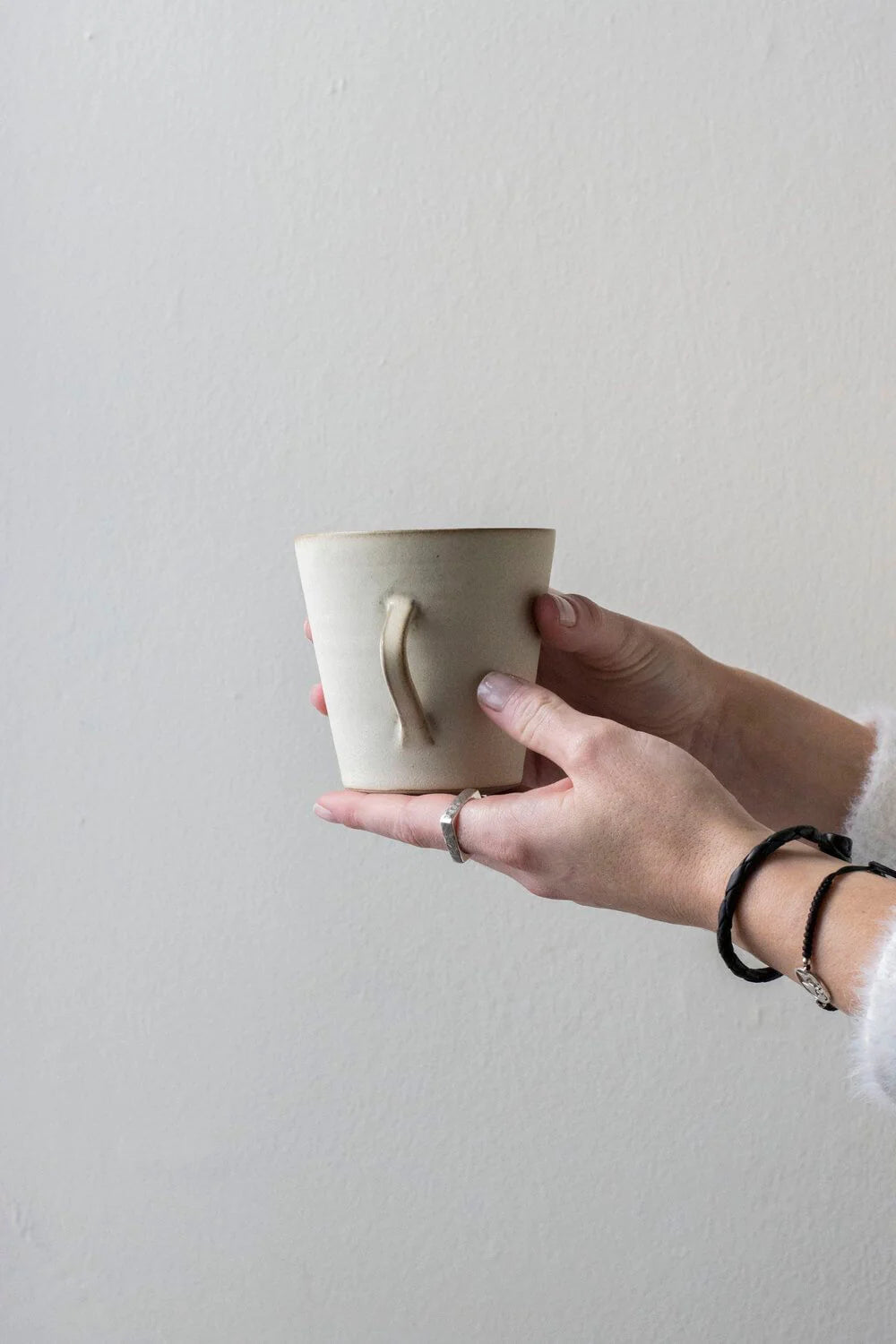A coffee mug held in the hand at Lifestory
