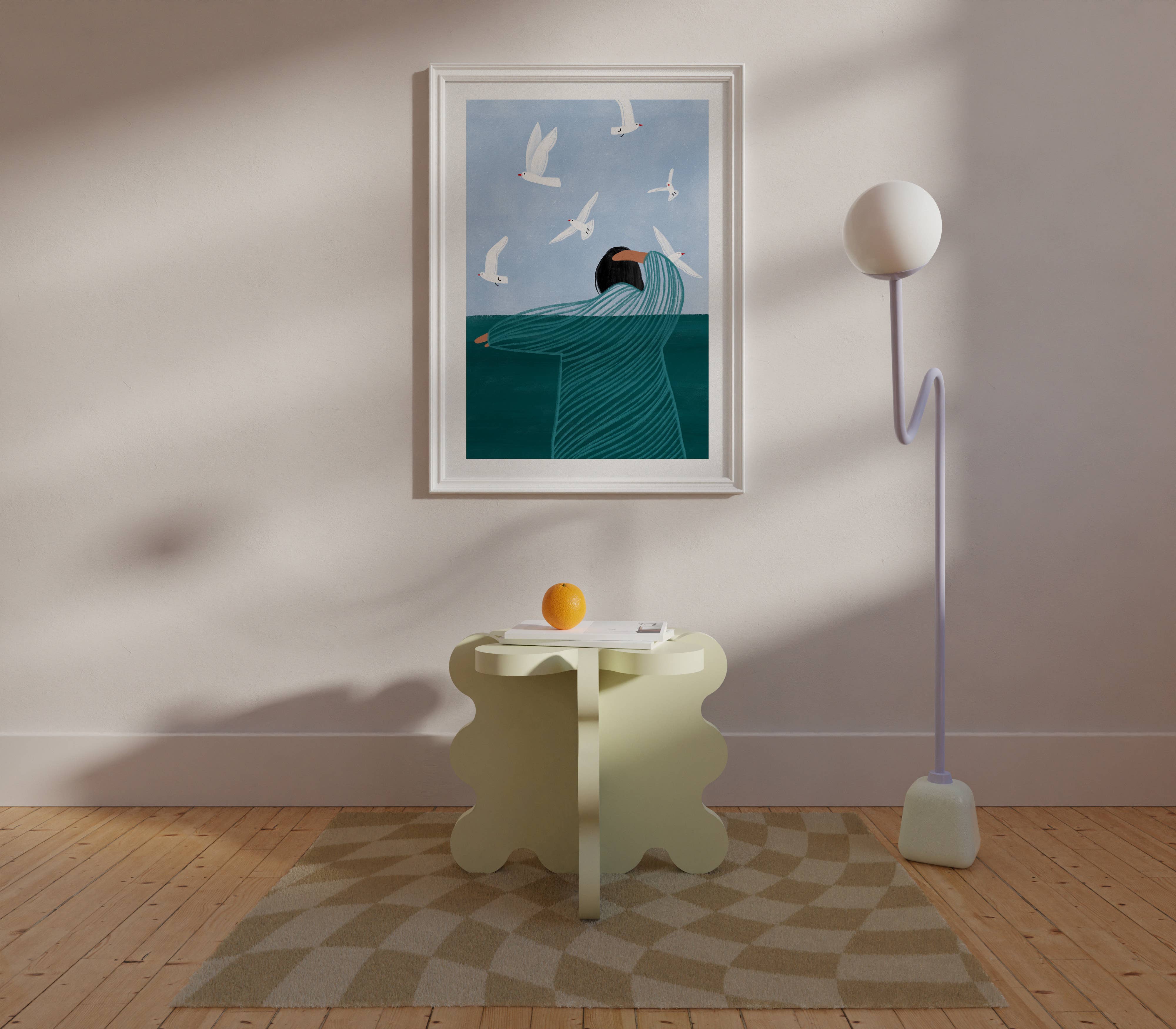 Bea Müller 'Seaside' A3 Unframed Art Print framed for reference and hanging above a curvy cream side table