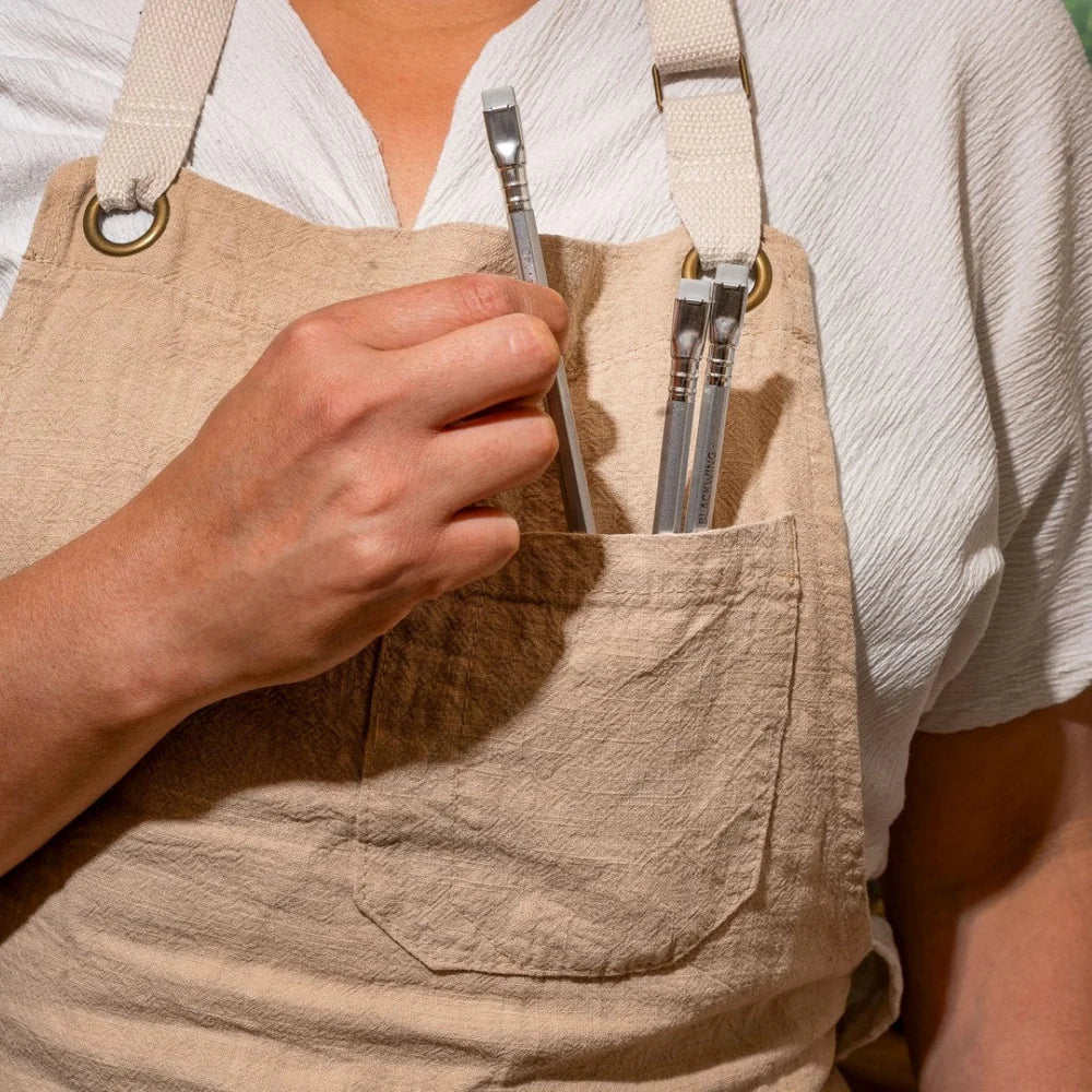 Person wearing a beige apron with Blackwing Volume 140 Ltd Edition Pencil in their pocket