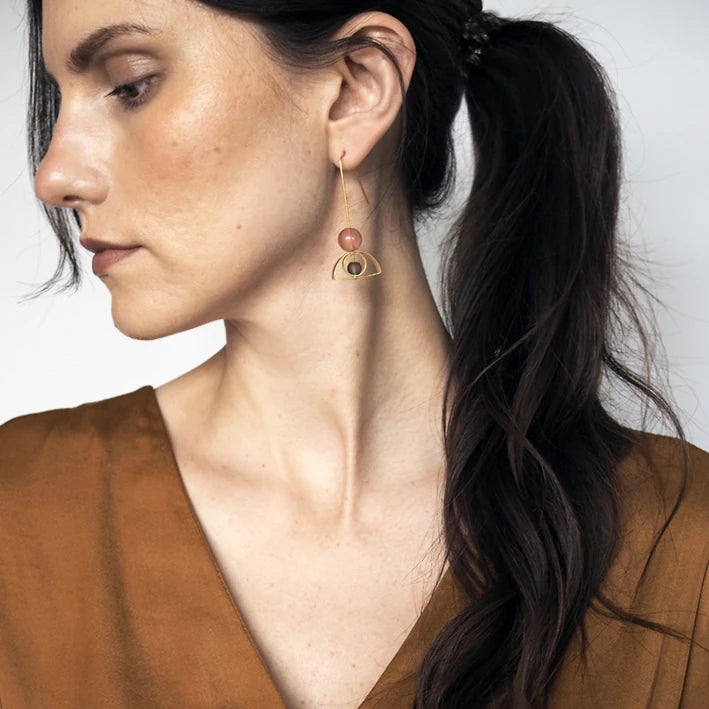 Pink & Grey Arch & Circle Brass Earrings by brass+bold worn by a white female model with brown air and a rust coloured top