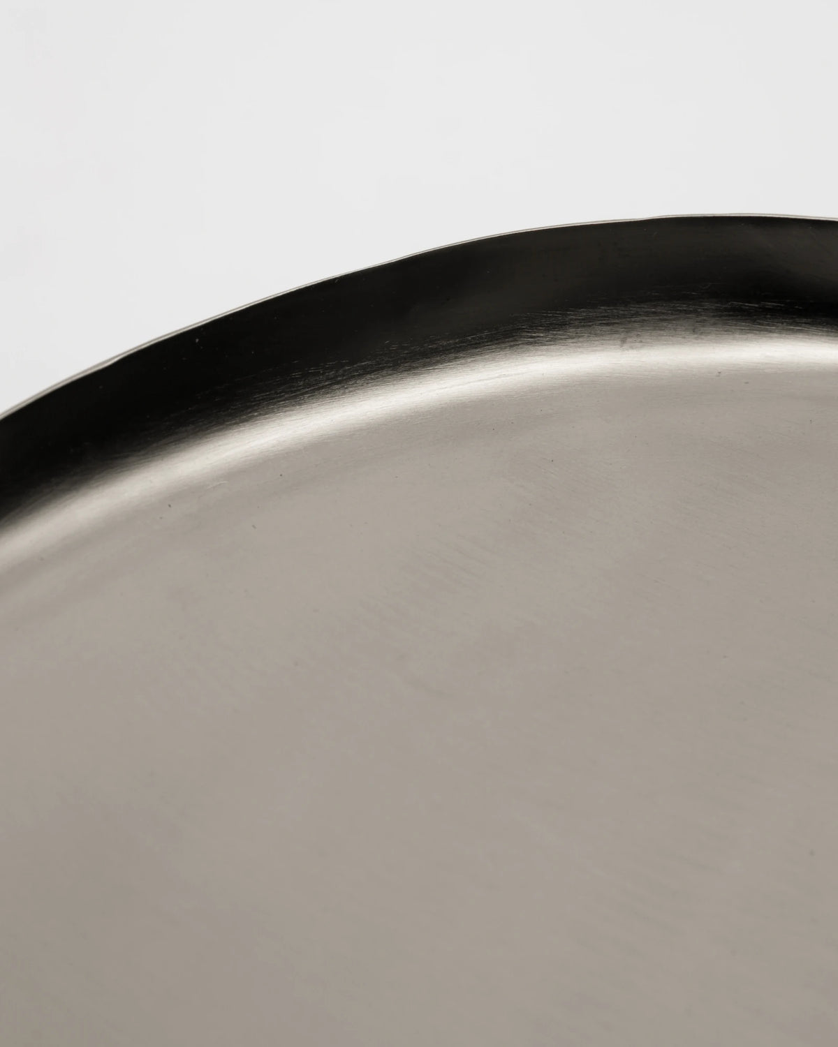 Close-up of House Doctor HDOsea Tray, Silver Finish with a brushed silver surface and a dark rim, photographed against a plain light background.