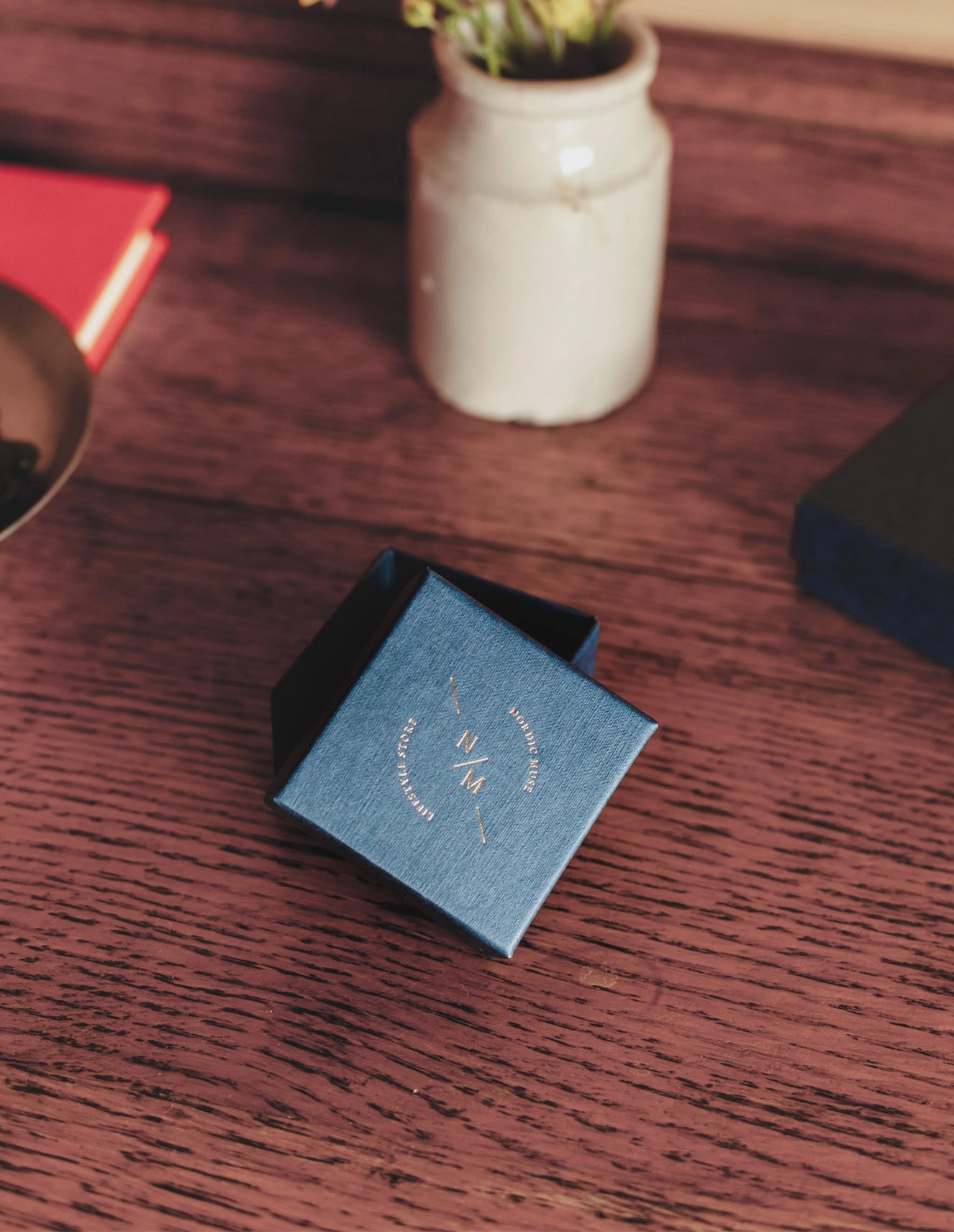 Nordic Muse blue ring box on a dark wooden table