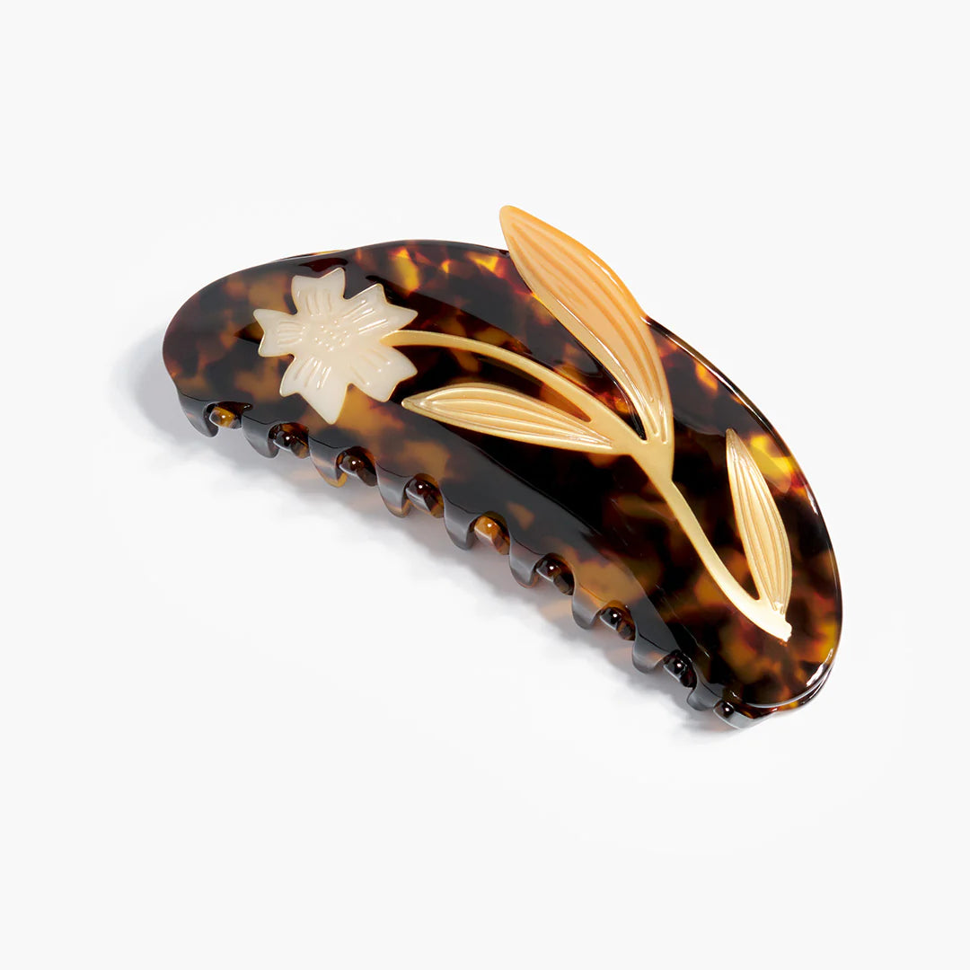 Tortoiseshell hair clip with floral design on a white background