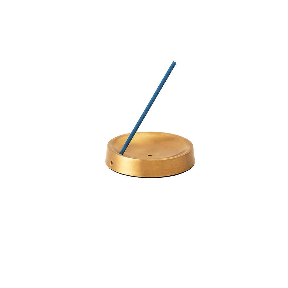 Incense stick in a brass holder on a white background
