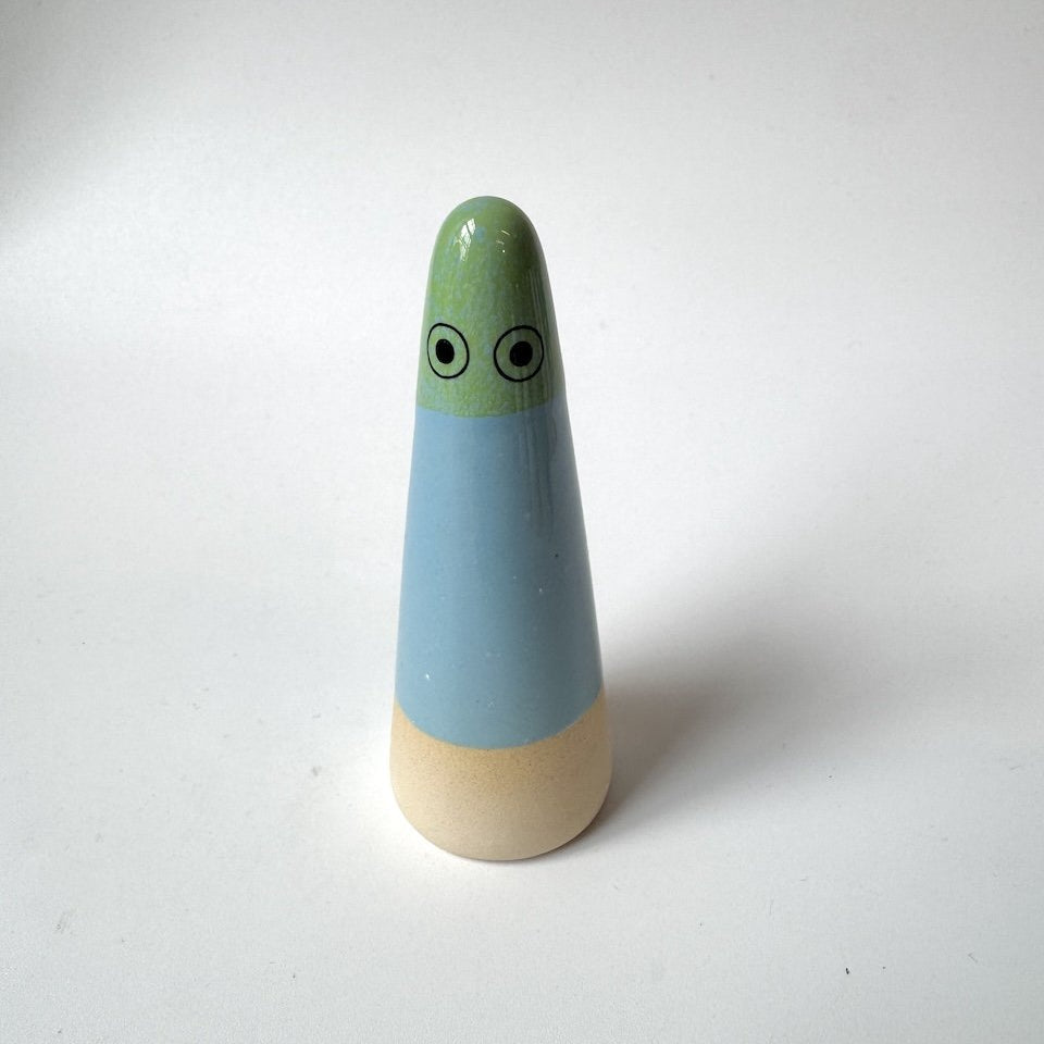 Nora Studio Arhoj ghost, featuring a light green head with cartoon eyes, a light blue middle section, and a natural beige wooden base, set against a plain white background.