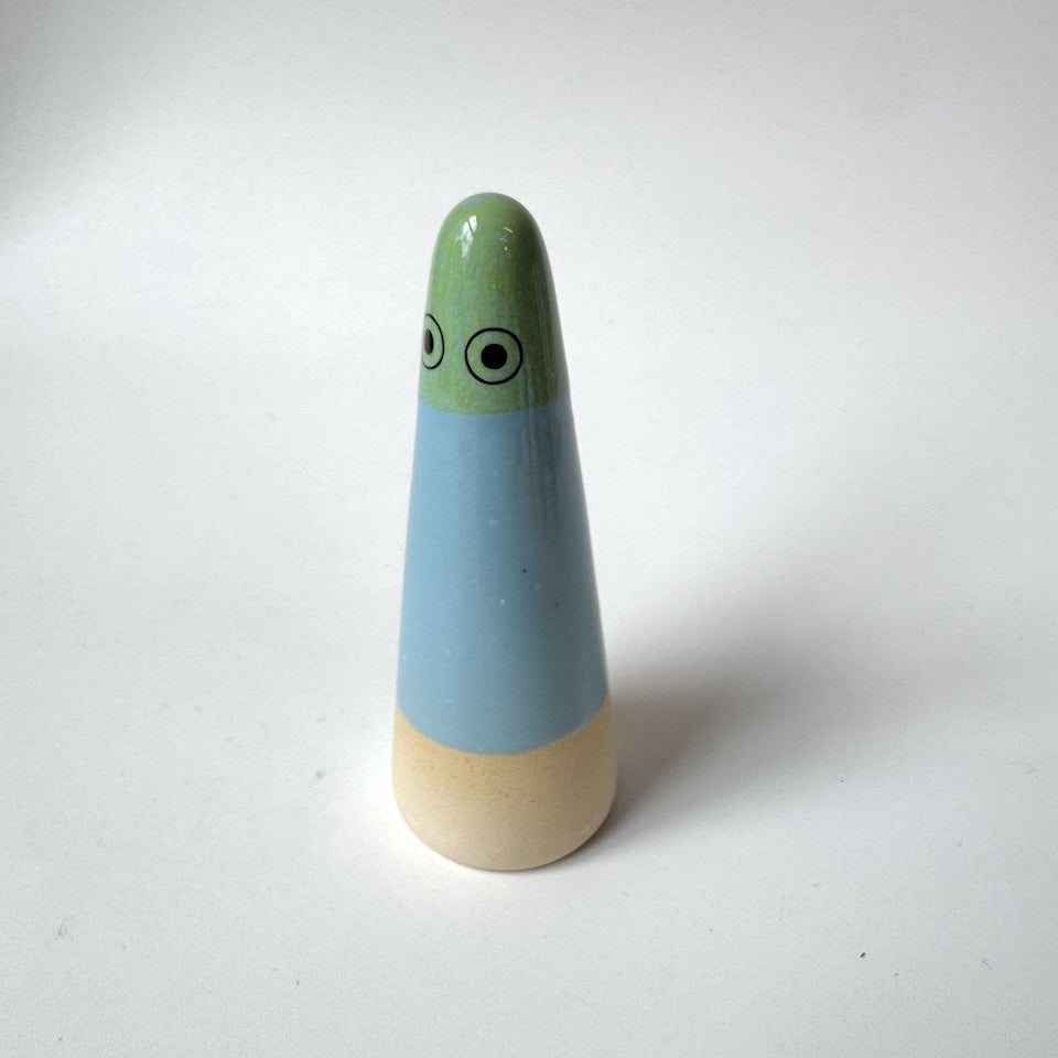 Nora Studio Arhoj ghost, featuring a light green head with cartoon eyes, a light blue middle section, and a natural beige wooden base, set against a plain white background.