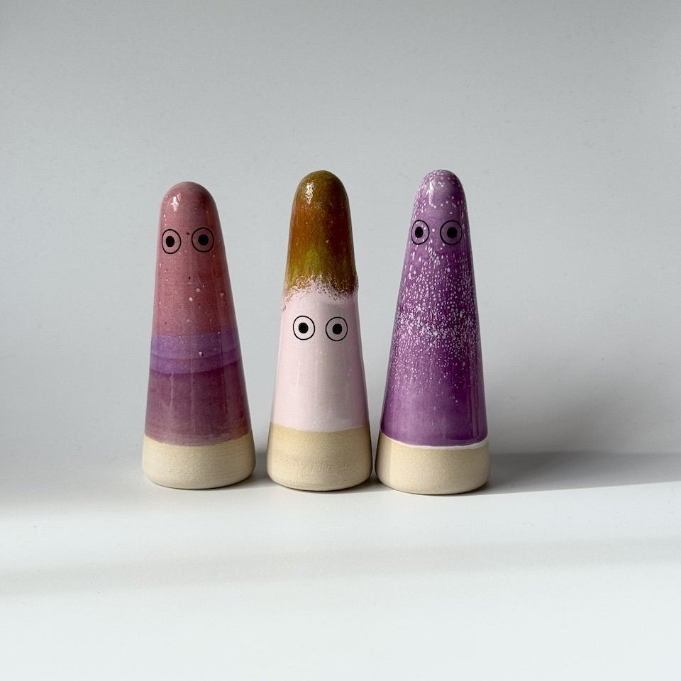 Three studio Arhoj ghosts standing on a light grey studio background.