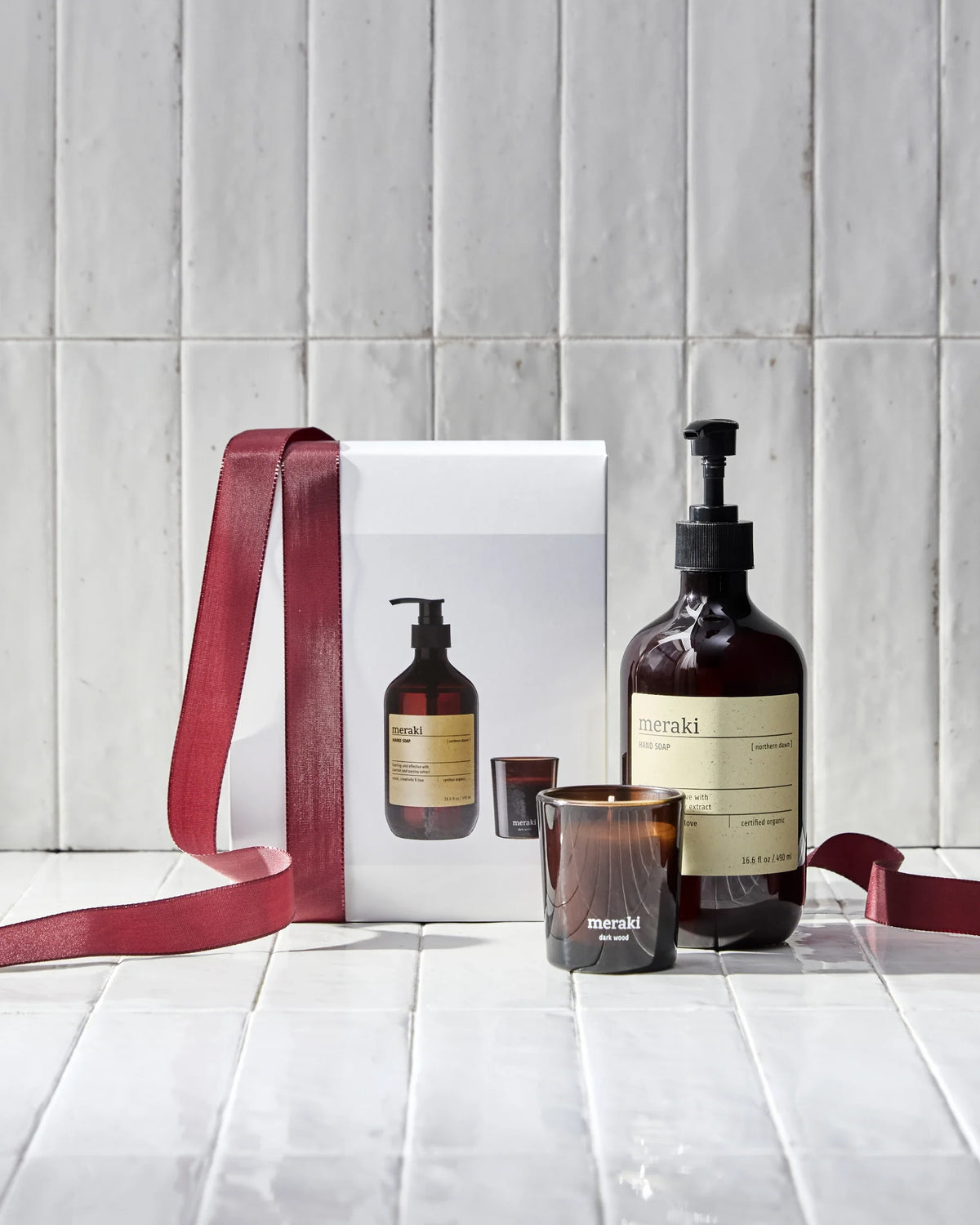 Merakin skincare products with a gift box on a tiled floor