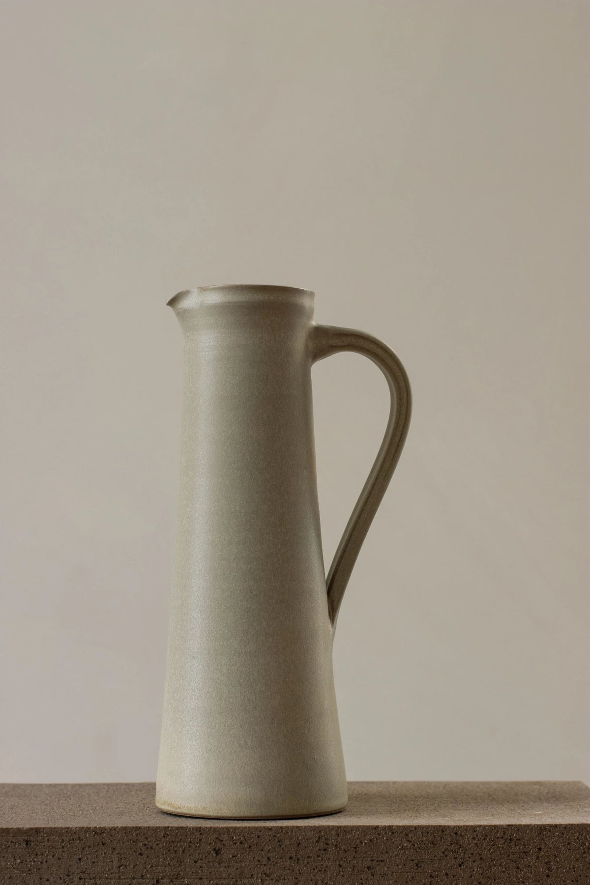A Borja Moronta jug in pearl grey glaze sitting on a stone counter