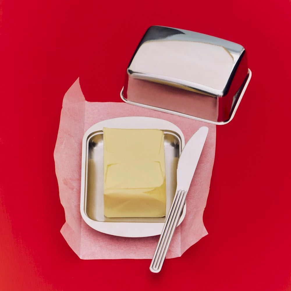 HAY essential steel butterbox open with butter in it displayed on a red background