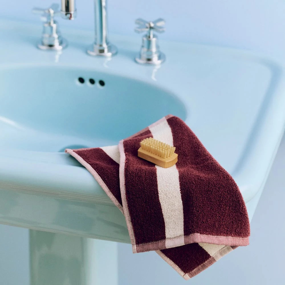 HAY Burgundy stripe wash cloth on a blue sink