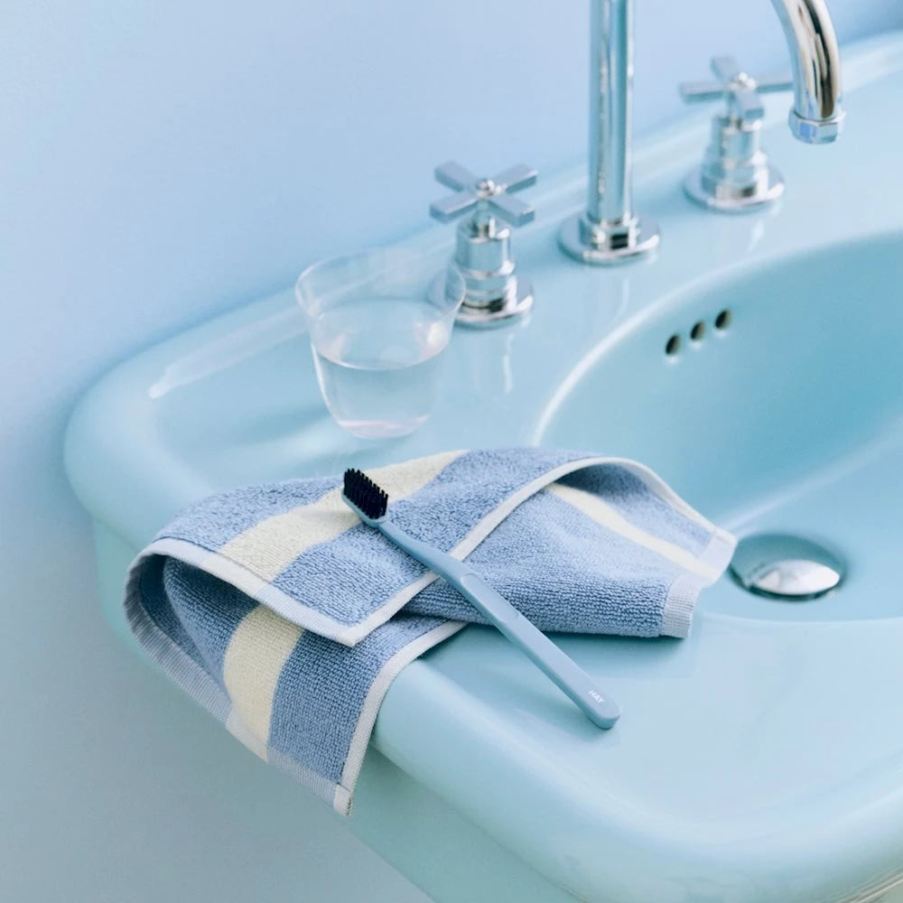 HAY blue stripe wash cloth on a blue sink.
