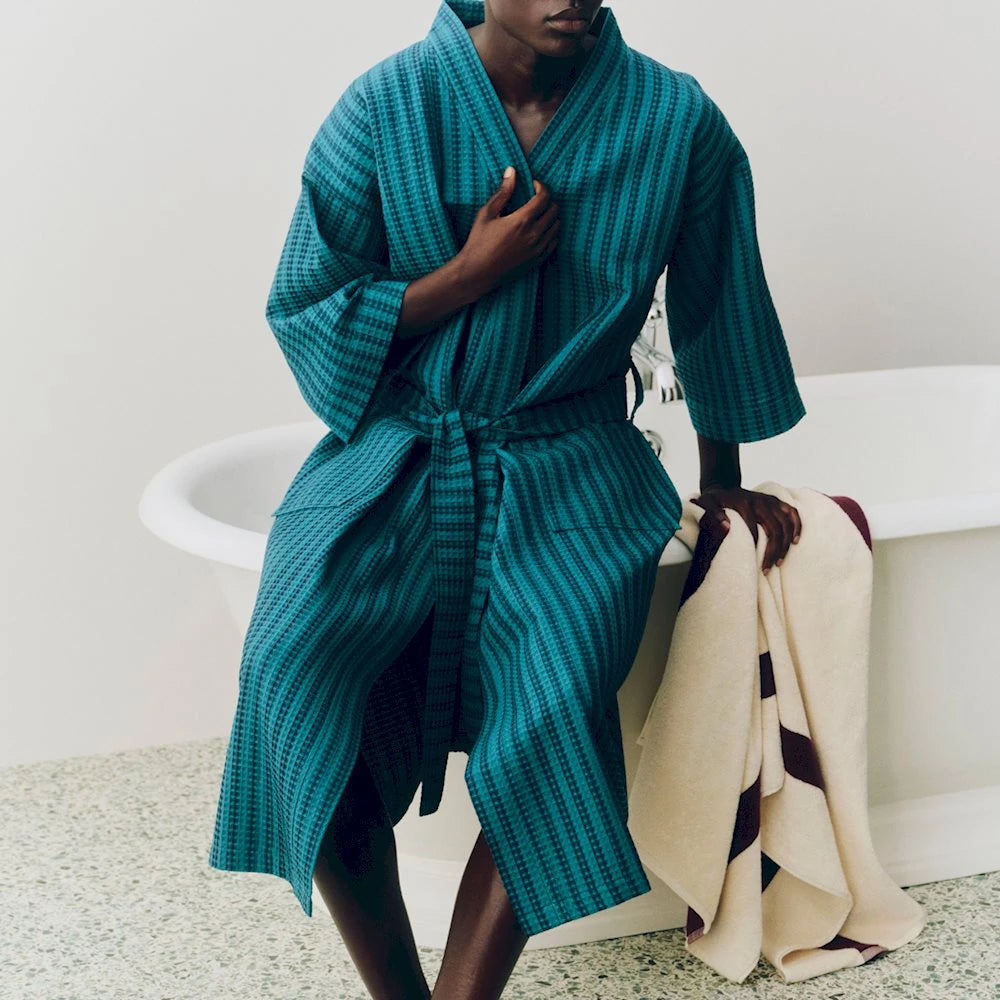A model wearing the petrol blue strip waffle bathrobe by HAY