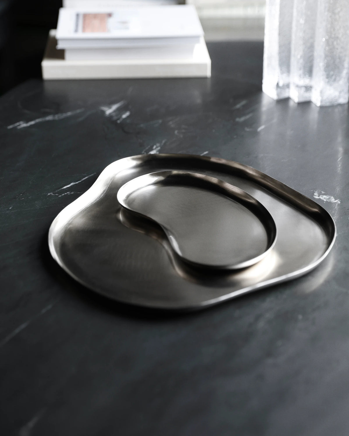 A House Doctor HDOsea Tray, Silver Finish, organic-shaped tray with a smaller nested oval dish, displayed on a dark marble tabletop.