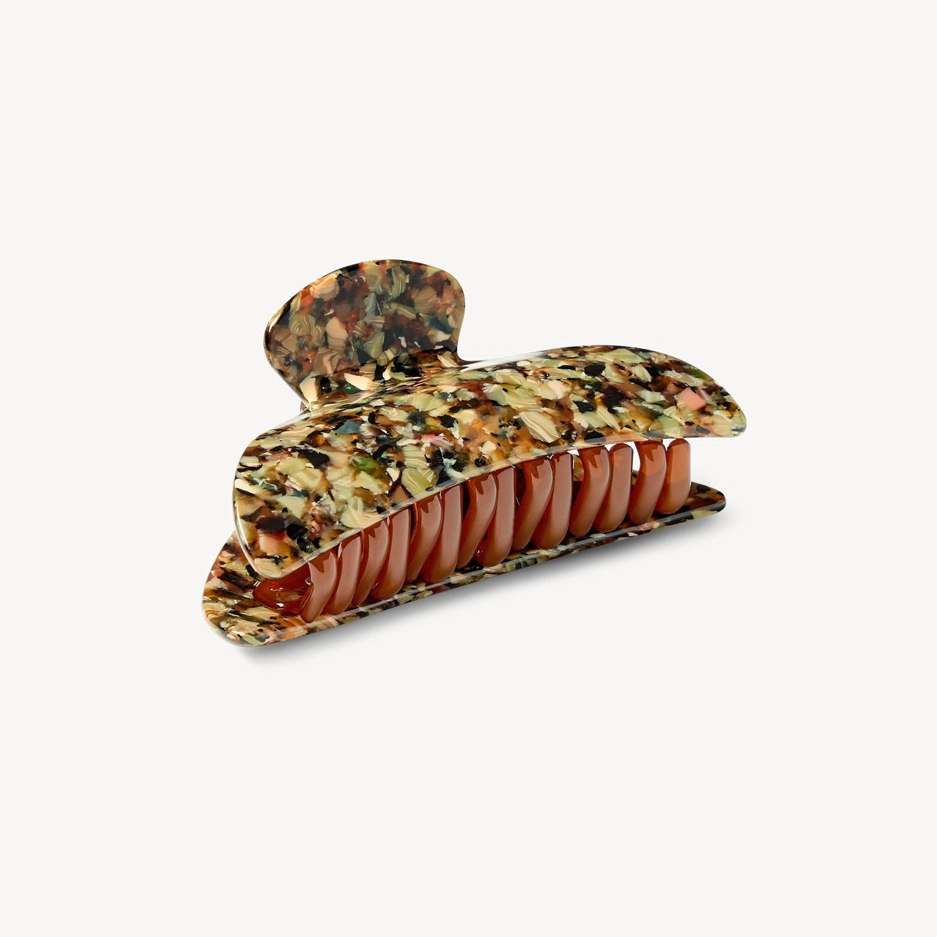 Machete tortoiseshell hair claw clip with a marbled pattern of brown, green, and black, featuring a warm reddish-brown inner lining, shown on a light gray background.