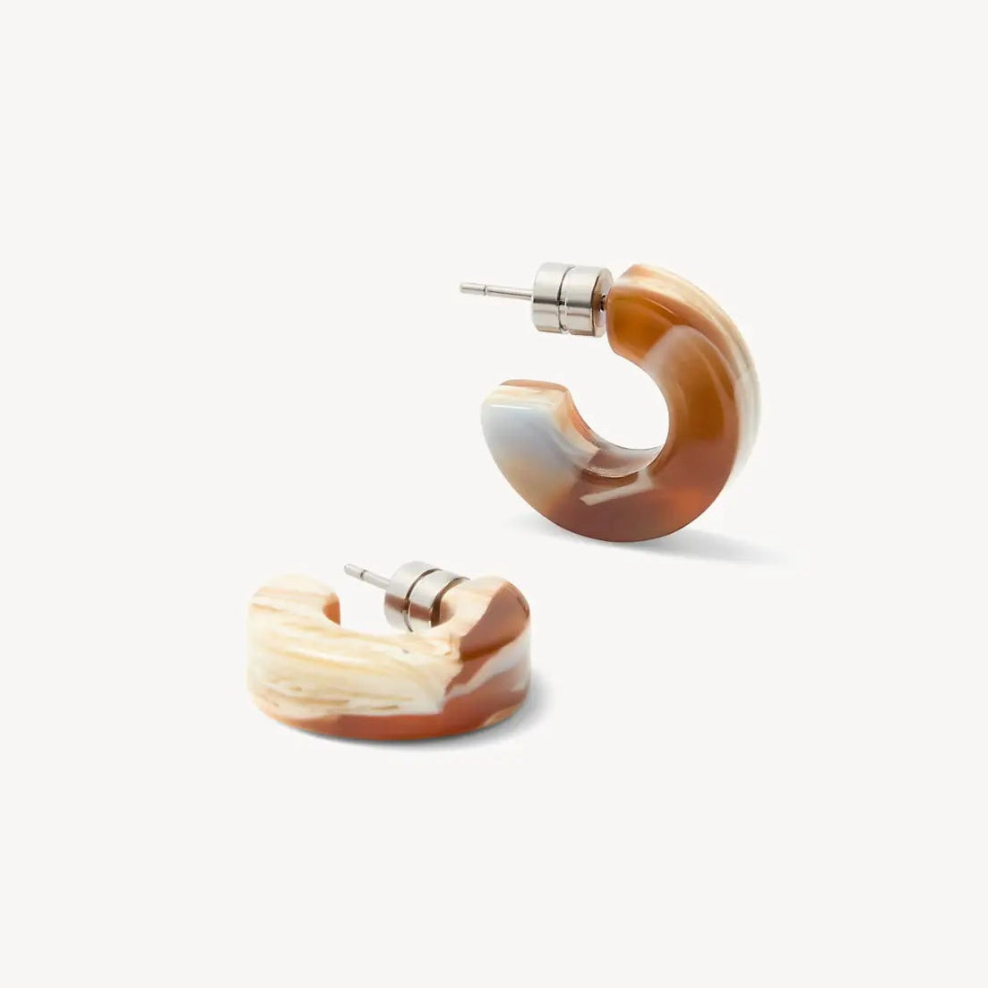 A pair of curved hoop earrings made from a marbled resin blend of brown, cream, and white, with silver-tone posts, shown on a clean off-white background.