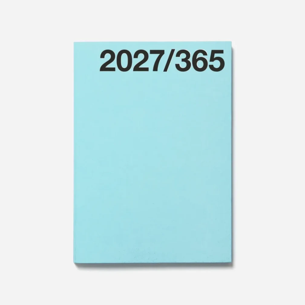 A light blue Marjolein Delhaas planner cover with the white text '2027/365' printed at the top, shown on a light grey background.