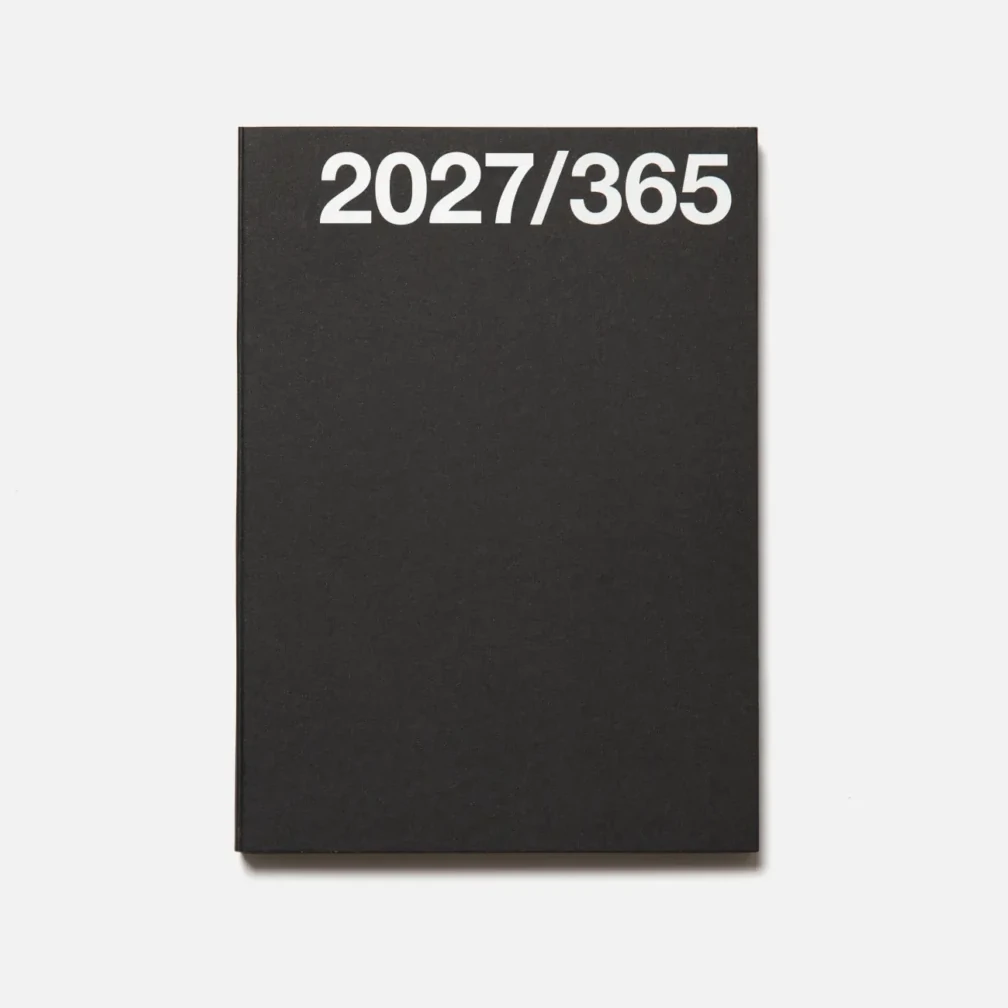 A minimalist black Marjolein Delhaas journal with the white text '2027/365' printed at the top, shown against a clean off-white background.