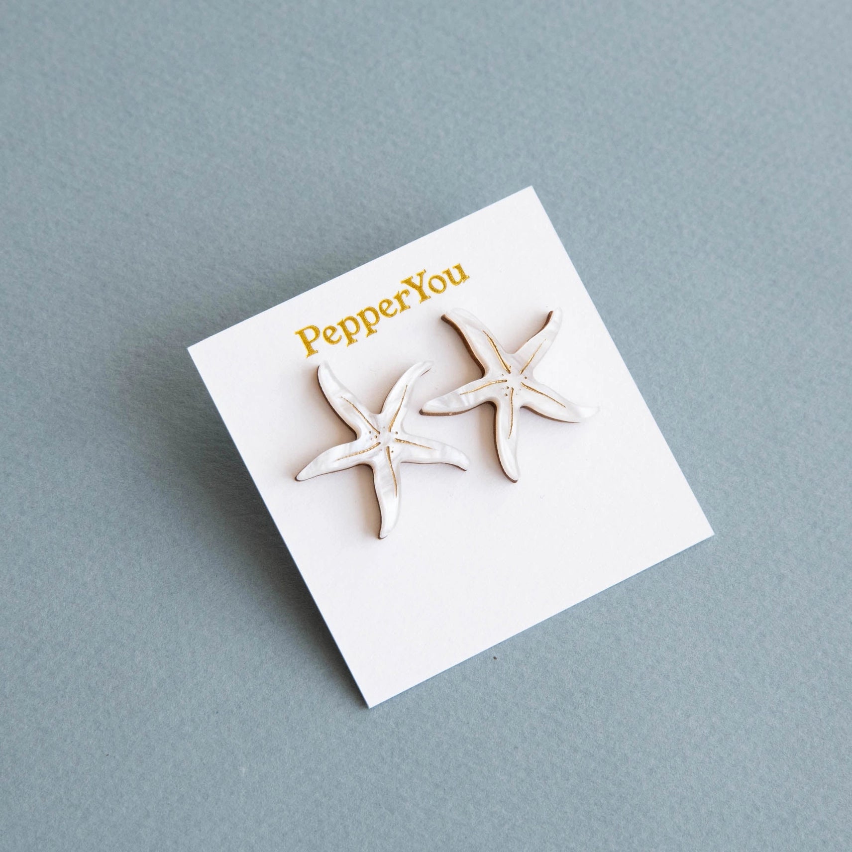 Pepper You Acrylic & Wood Starfish Stud Earrings on a branded display card